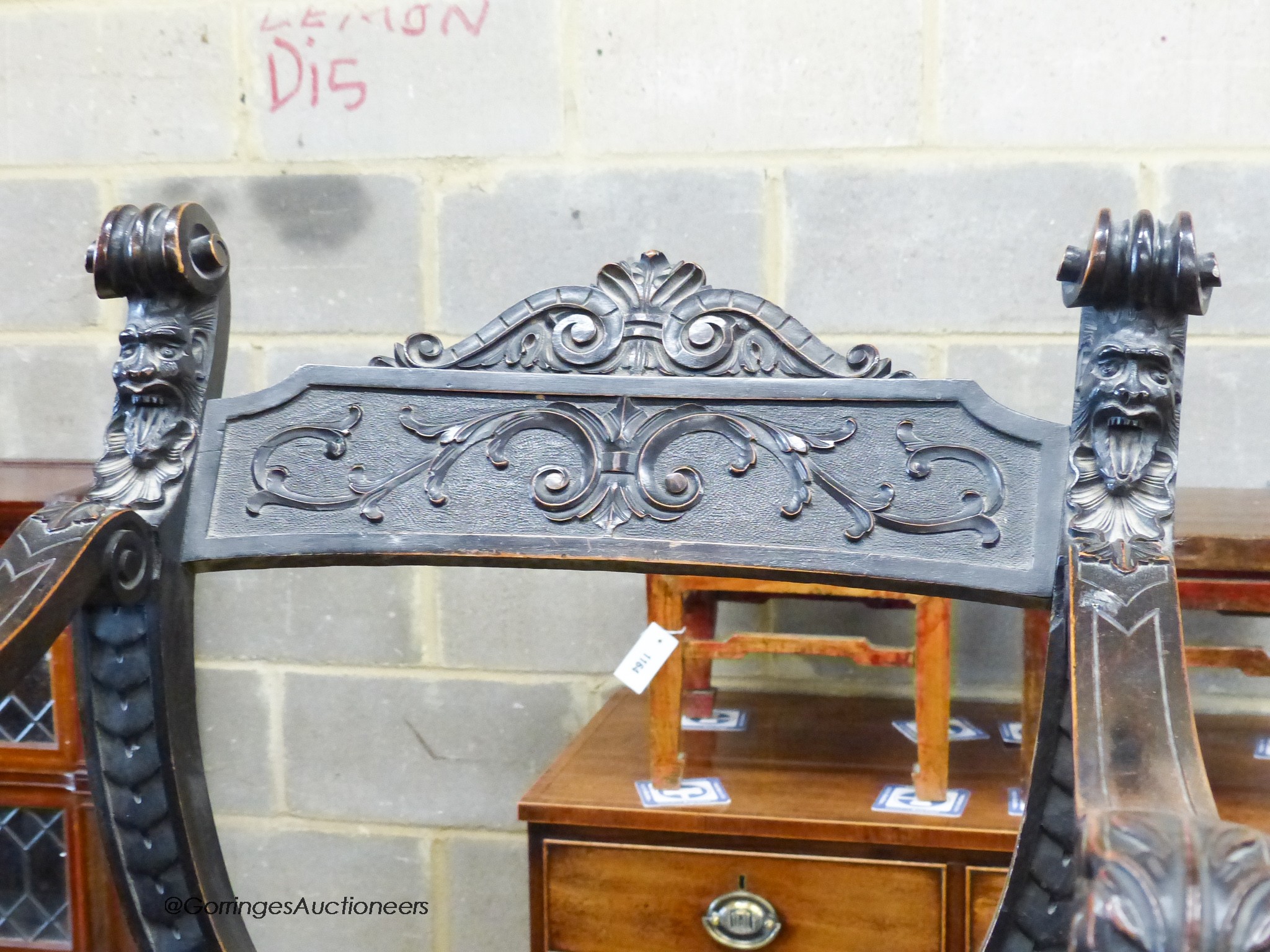 An Ebonised Sagrada style x-frame elbow chair.